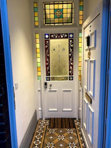 a hallway with a white door with stained glass at The Beaches - En-suite Rooms in Redcar