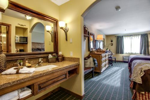 a bathroom with a sink and a bed and a mirror at Bavarian Lodge in Leavenworth