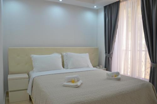 Andaluni Beach Apartments في برزنو: غرفة نوم عليها سرير وفوط