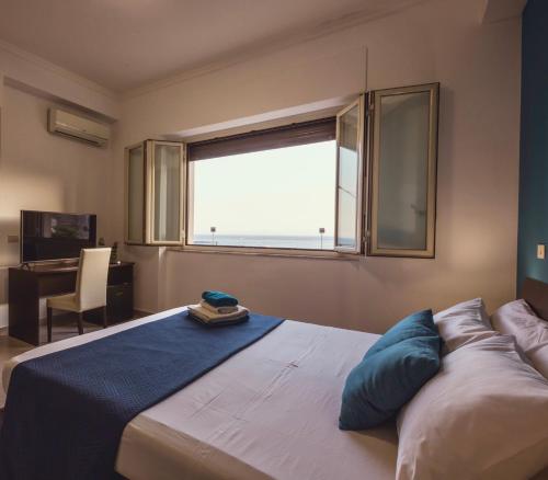 Schlafzimmer mit einem großen Bett und einem Fenster in der Unterkunft Oasis in Acitrezza