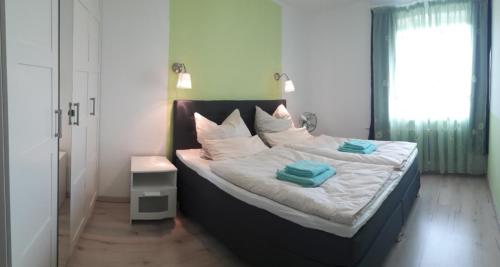 a bed with white sheets and blue towels on it at Ferienwohnung Siesta in Bad Harzburg