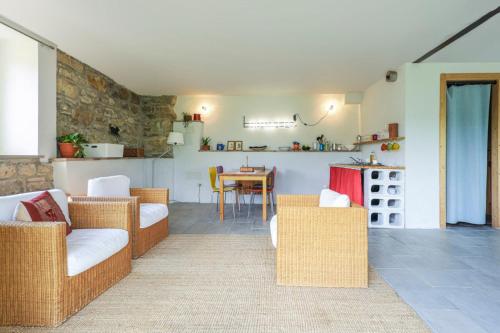 a living room with wicker chairs and a table at Nido d’amore nei colori in Dernice