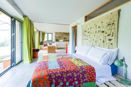 a bedroom with a bed with a colorful quilt at Nido d’amore nei colori in Dernice