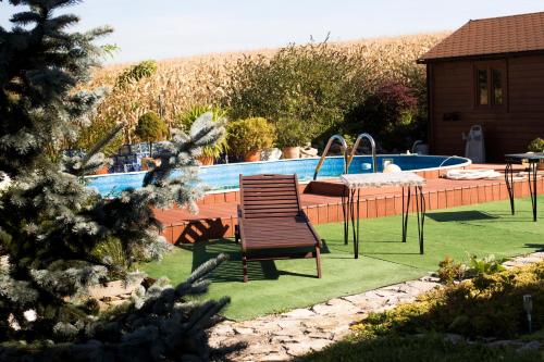 a wooden chair sitting next to a swimming pool at Villa Bawaria in Cieszyn