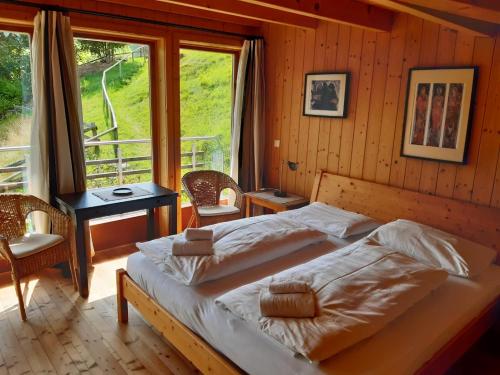 a bedroom with a bed and a table and a window at Chalet Verdino in Bad Kleinkirchheim