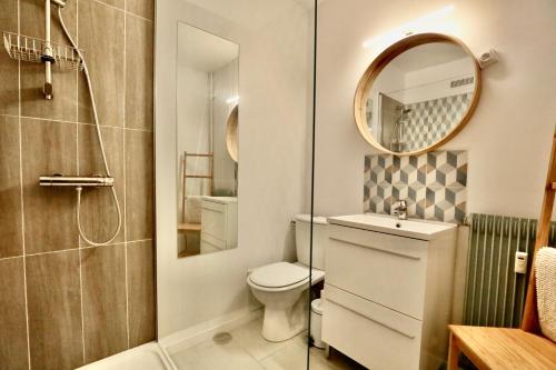 La salle de bains est pourvue de toilettes, d'un lavabo et d'un miroir. dans l'établissement Studio Royal de la Plage, à Deauville