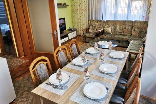 a dining room table with chairs and plates on it at Apartman Škudar in Bjelovar