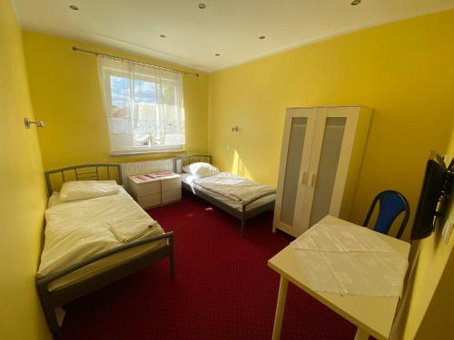 a small room with two beds and a window at Hotel Tequila in Międzyrzecz