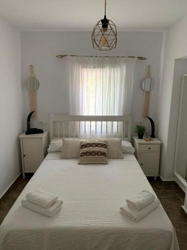 a bedroom with a large white bed with two towels on it at Panorama Village in Barbate