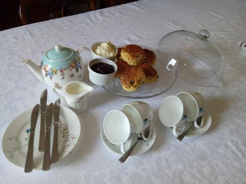 a table with a teapot and a plate of food at Abbeyview House B&B and Glamping in Abbeyshrule