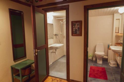 a bathroom with a sink and a toilet and a door at Brösarp Källagården Stora Gårdslägenheten in Brösarp
