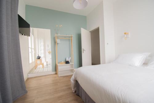 1 Schlafzimmer mit einem großen weißen Bett und einem Badezimmer in der Unterkunft 15ème droite - Tour Perret - Centre-Ville - 4 étoiles in Amiens