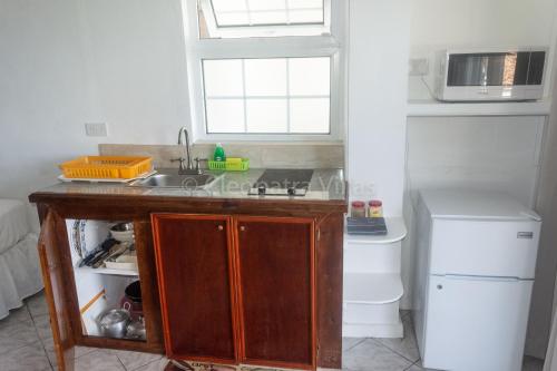 a small kitchen with a sink and a refrigerator at Cleopatra Villas - Sea View in Rodney Bay Village