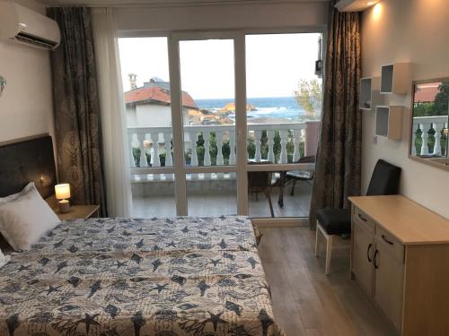 a bedroom with a bed and a view of a balcony at Студио Сънрайз А28, Лозенец in Lozenets