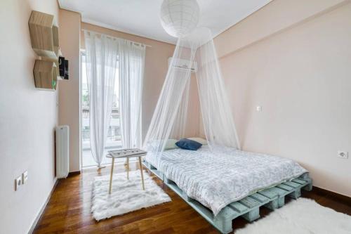 1 dormitorio con cama con dosel y ventana en Cosy and Confortable en Atenas