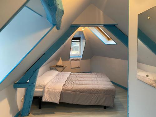 une chambre avec un lit dans un grenier dans l'établissement Bois Flotté, au Tréport
