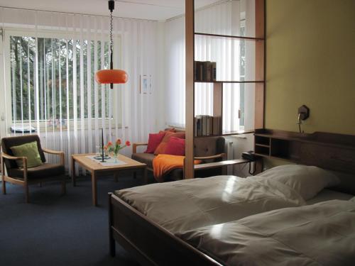 a bedroom with a bed and a living room at Hotel-Café "Schauinsland" in Horn-Bad Meinberg