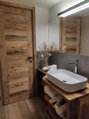 a bathroom with a white sink and a mirror at Au Fond du Bourg in Aosta
