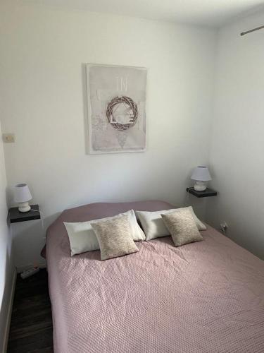 une chambre avec un lit avec deux oreillers dessus dans l'établissement Les Rosiers, à Lapalud