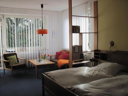a bedroom with a bed and a couch and a table at Hotel-Café "Schauinsland" in Horn-Bad Meinberg