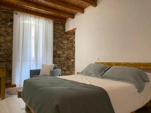 a bedroom with a large bed and a window at Casa da Igrejja in Almodôvar
