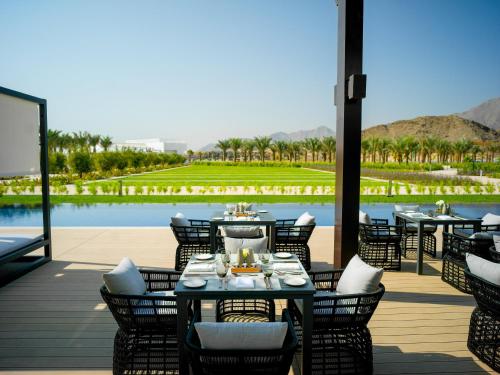 a restaurant with tables and chairs on a deck at InterContinental Fujairah Resort by IHG in Al Aqah