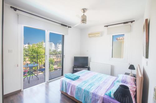 a bedroom with a bed and a balcony at Ariella Villa in Protaras