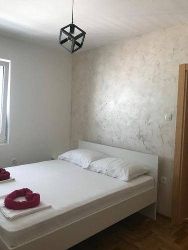 a bed with white sheets and red towels on it at Apartman Tijana in Budva