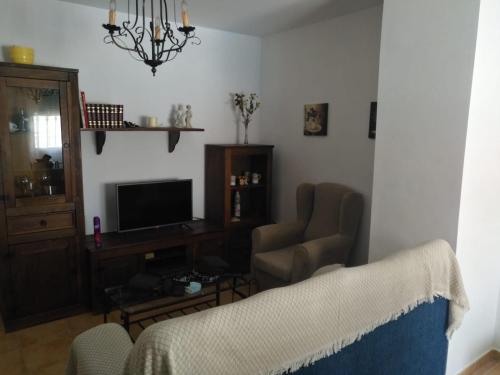 a living room with two chairs and a television at Casa Lucía y Clara benaojan in Benaoján