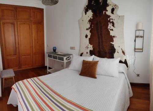 a bedroom with a white bed and a wooden cabinet at Ramón y Cajal in Estepona