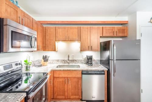 a kitchen with wooden cabinets and stainless steel appliances at Maui Vista in Kihei