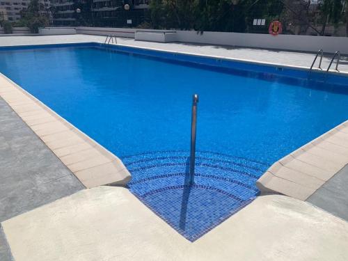 a large blue swimming pool with a pole in it at Melo sur in Playa de las Americas