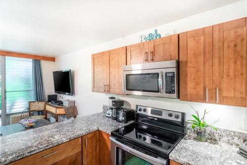 a kitchen with a stove and a microwave at Amazing Kihei Kai Nani - Maui Vista One Bedroom Condos in Kihei