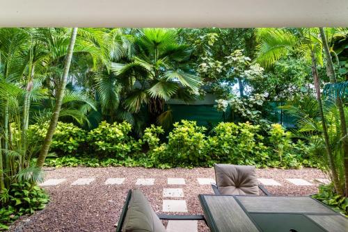 a patio with a table and chairs and palm trees at Amazing Kihei Kai Nani - Maui Vista One Bedroom Condos in Kihei