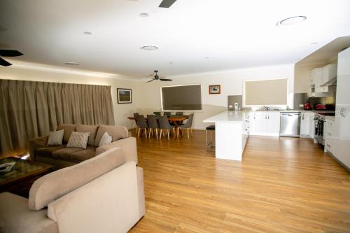 a living room with a couch and a kitchen at Elm Cottage in Tumut