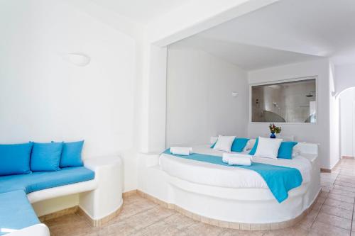 a white room with a bed and a couch at Aelia by Eltheon in Imerovigli