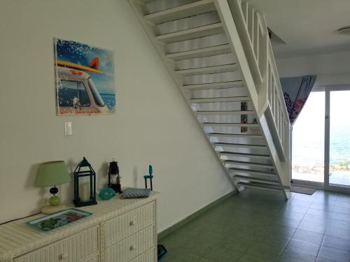 a living room with a staircase and a dresser and a stair case at Breathtaking View - Playa Lagun - Curacao in Lagun