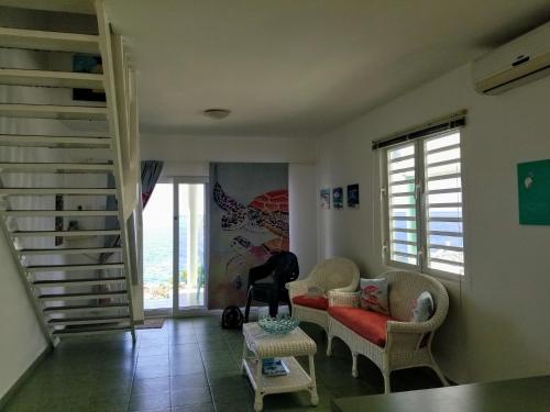 a living room with two chairs and a staircase at Breathtaking View - Playa Lagun - Curacao in Lagun
