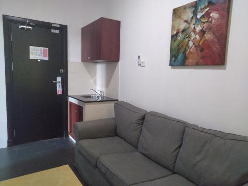 a living room with a couch and a painting on the wall at Ginasuite Hotel in Bandar Seri Begawan