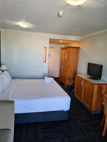 a hotel room with a bed and a television at Quality Inn Airport Heritage in Brisbane