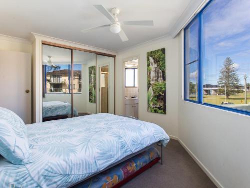 a bedroom with a bed and a large window at Heritage 202 in Tuncurry