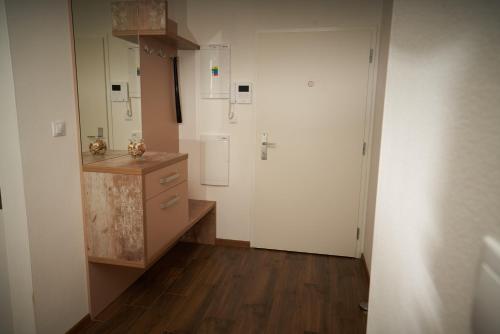 een keuken met witte muren en een houten vloer bij Apartman A&M in Banská Bystrica