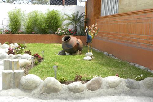 a garden with a vase and flowers in a yard at Kuna Hotel in Cuenca