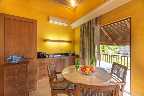 a kitchen with a table with a bowl of fruit on it at Buri Rasa Village Samui in Chaweng