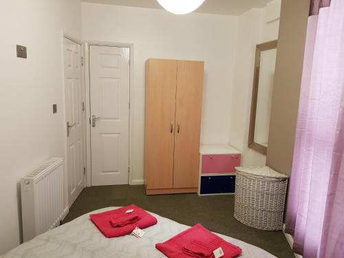 a bedroom with two red towels on a bed at Alhambra Suite in Ipswich