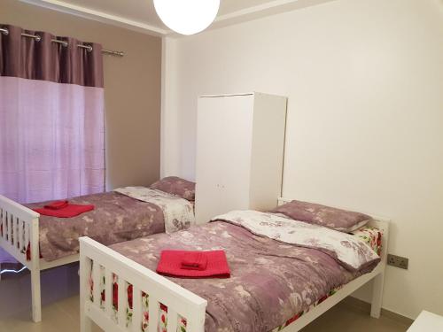 two beds in a room with red towels on them at Alhambra Suite in Ipswich