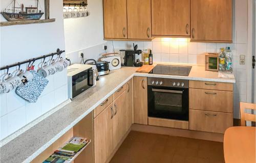 a kitchen with wooden cabinets and a stove top oven at Nice Home In Alt Bukow With Kitchen in Alt Bukow