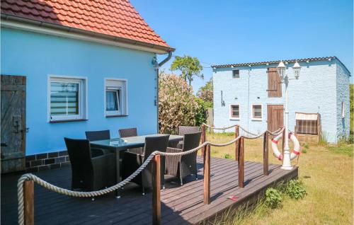 a wooden deck with a table and chairs on a house at Nice Home In Alt Bukow With Kitchen in Alt Bukow