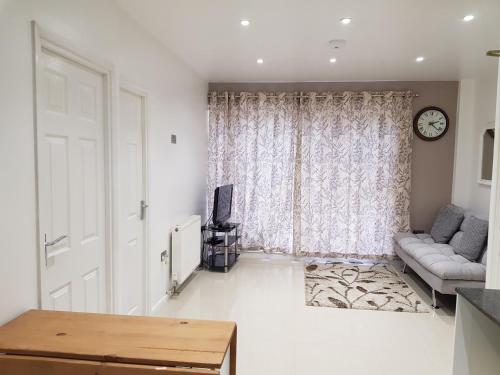 a living room with a couch and a window at Taj Suite in Ipswich