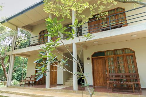 a house with wooden doors and a balcony at Nice Place Resort in Dambulla